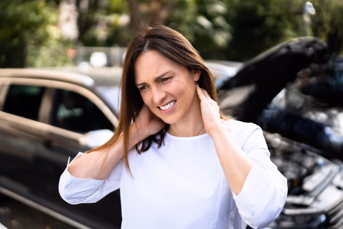 A woman holding her neck after a car accident.