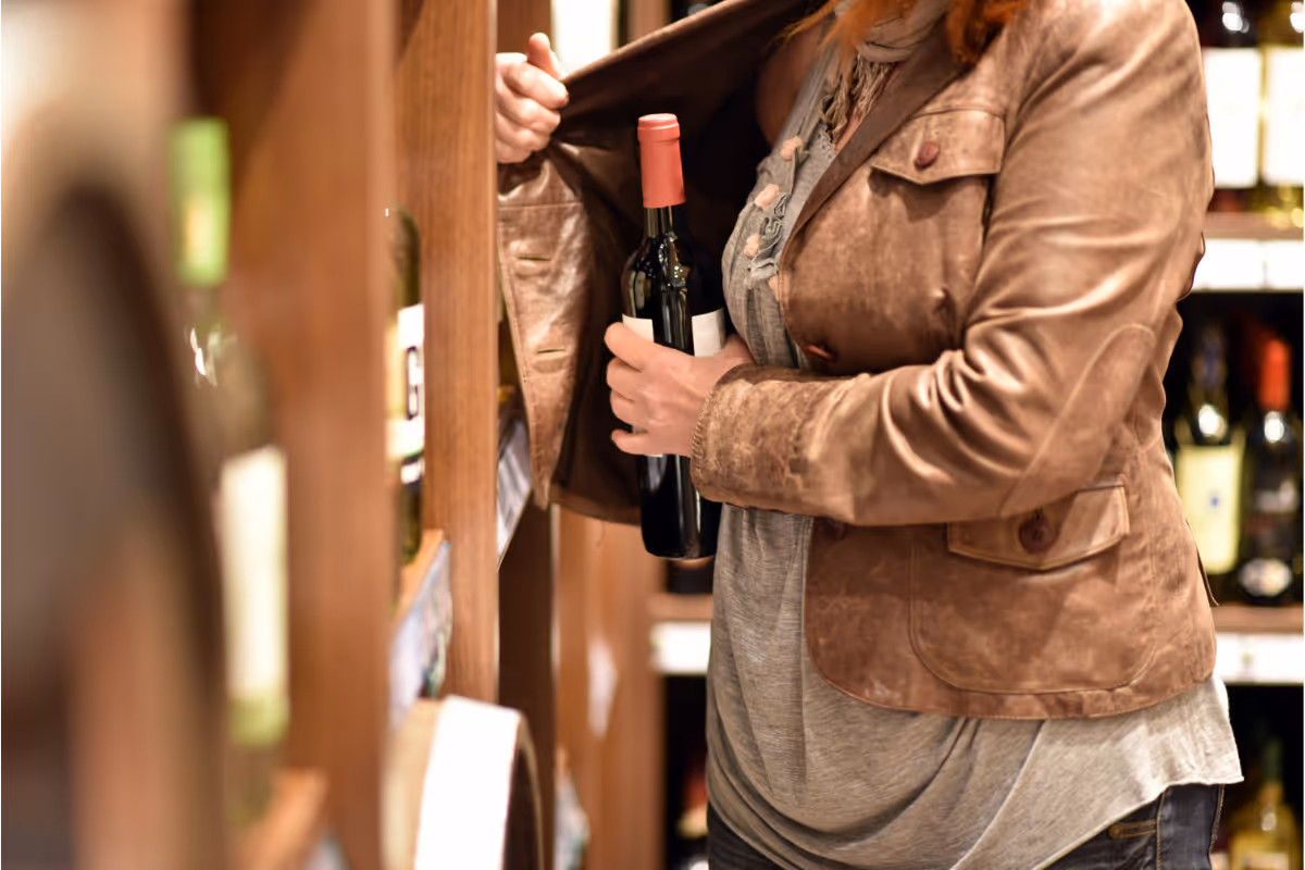 a person stealing a wine bottle