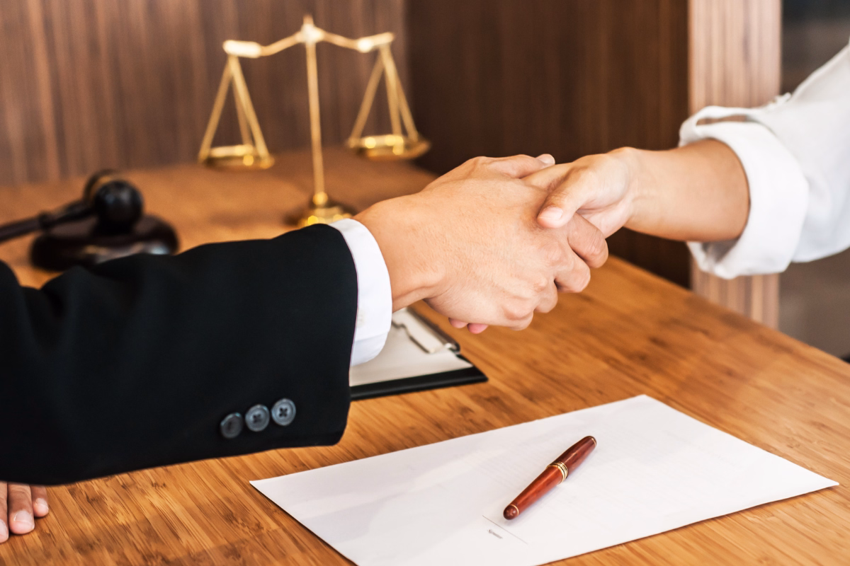 Lawyer working on paperwork with a gavel and lady justice next to him