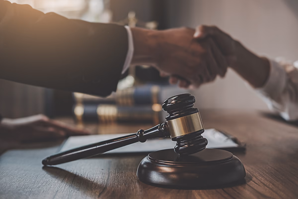 Lawyer working on paperwork with a gavel and lady justice next to him