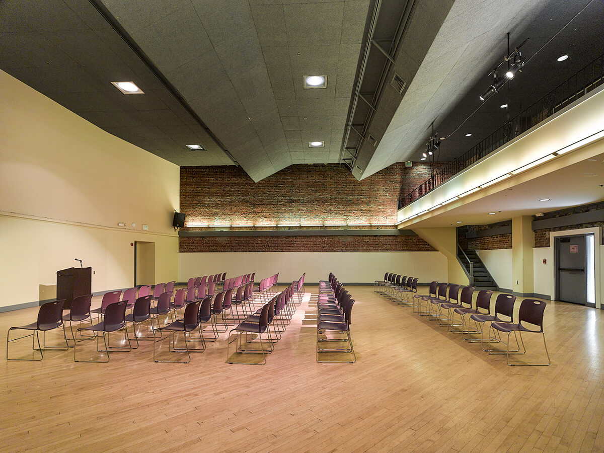 The Women’s Building auditorium configured with rows of chairs facing a podium, ideal for presentations or lectures.