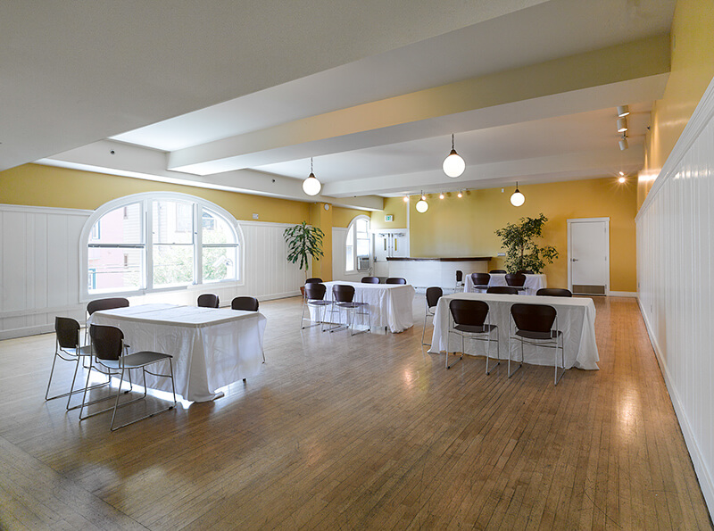 Audre Lorde Room arranged with rectangular tables and chairs for an event or workshop.