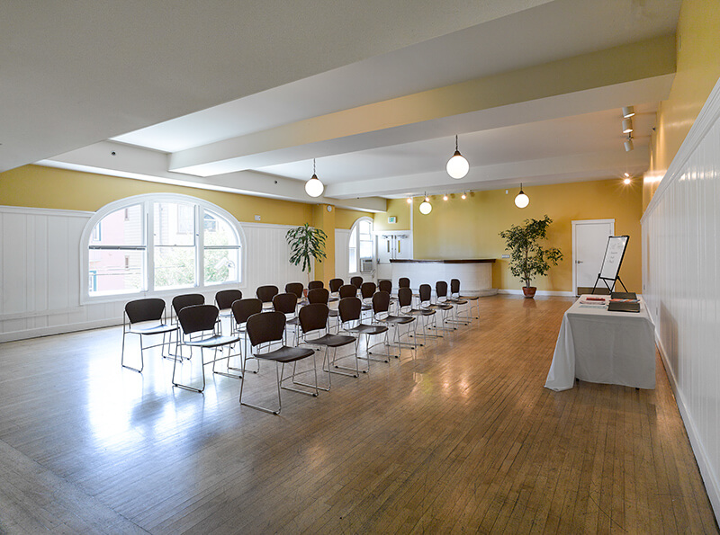Side view of Audre Lorde Room arranged in lecture-style with chairs facing a presentation table.