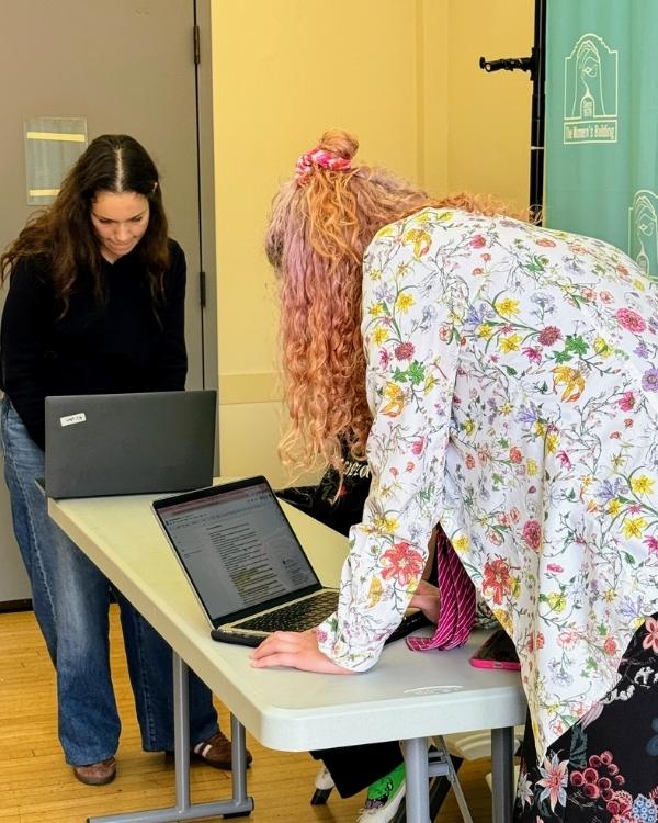 Staff working together at a table with laptops during an indoor event.