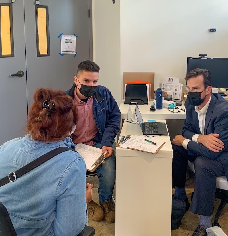 Two legal professionals speak with a community member during a legal clinic at The Women’s Building, providing personalized support in a safe and welcoming environment.