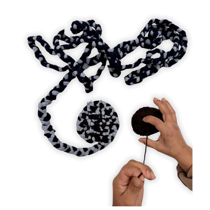 Hands holding yarn and braided textile pieces in black and white.