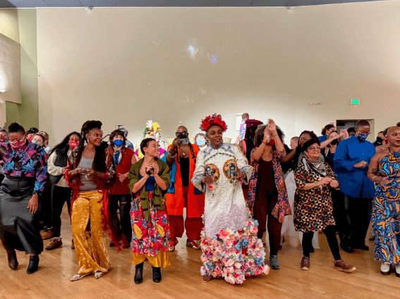 Community members dancing together in colorful attire during a celebration.