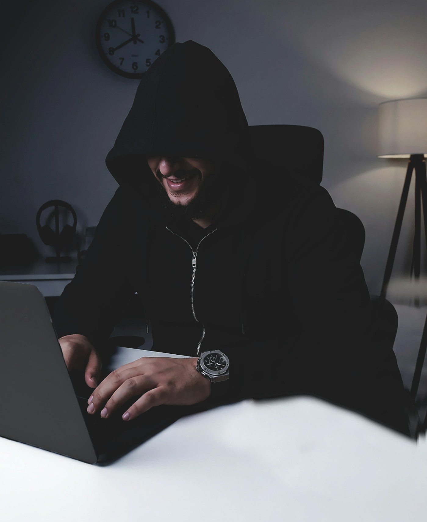 Agency owner typing on laptop late at night, screen glow in dark room