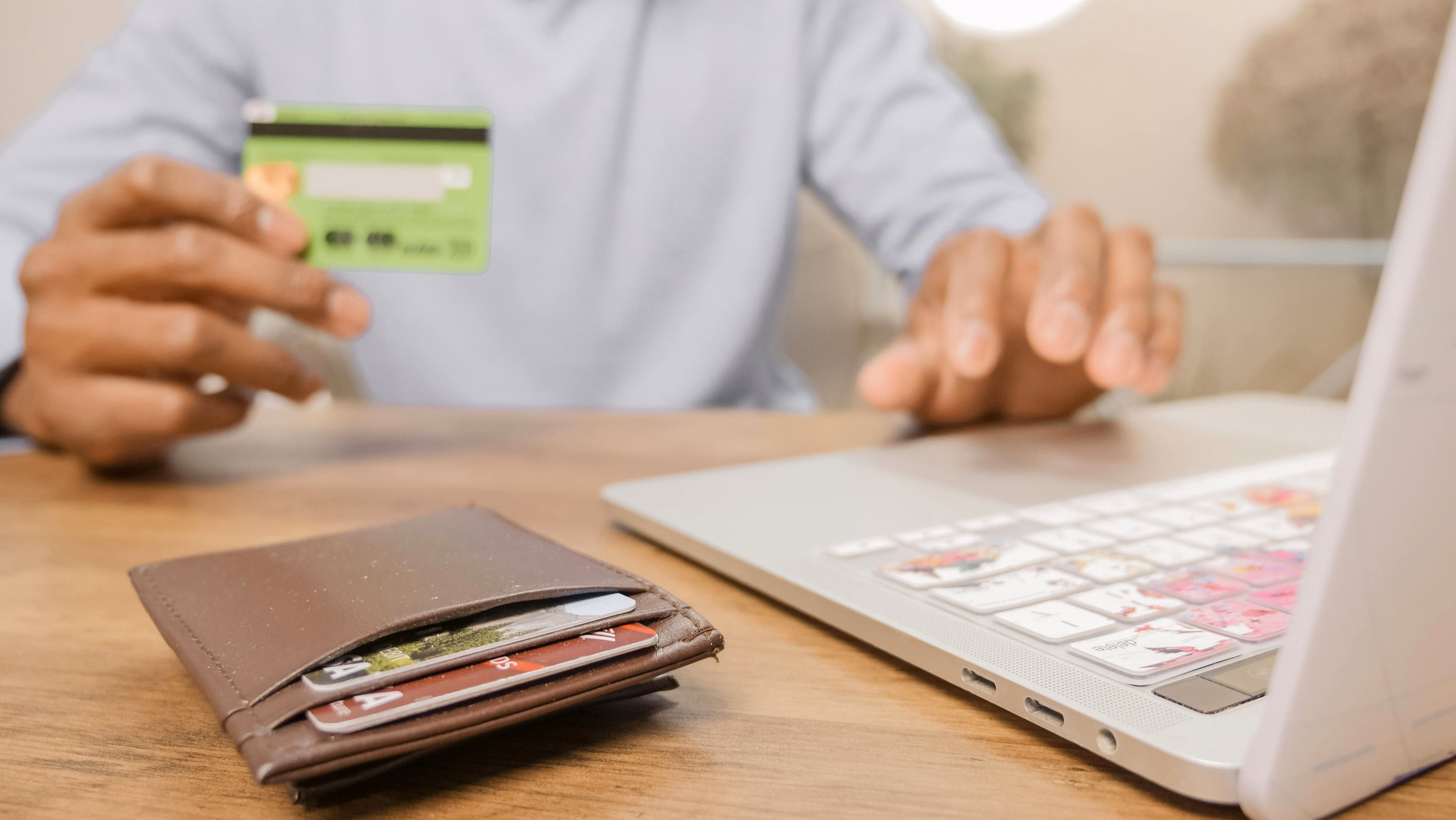 Person Holding A Bank Card While Online Shopping