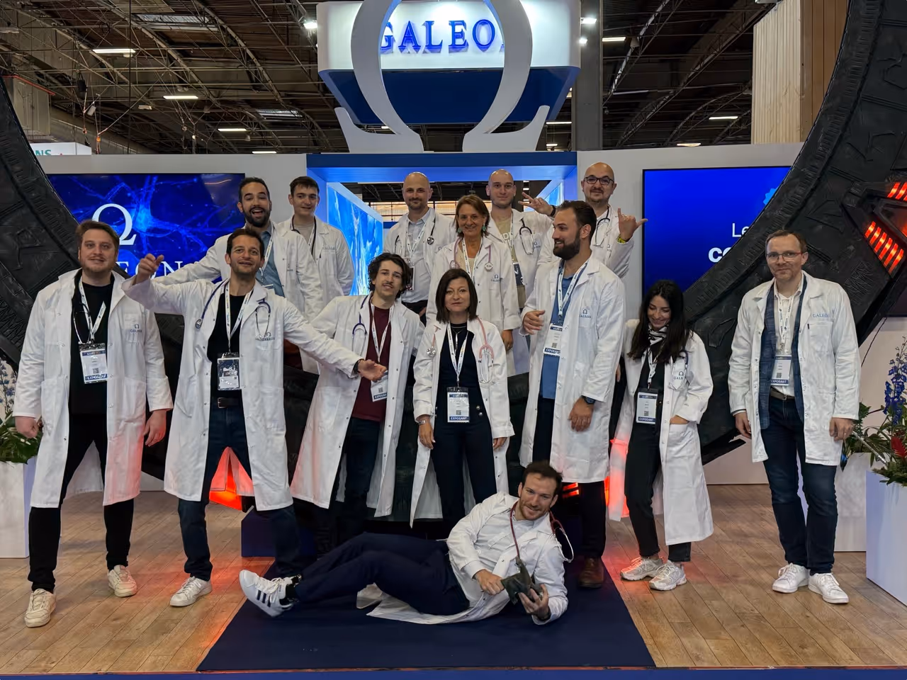 Équipe Galeon en blouses blanches posant devant leur stand lors d'un salon professionnel