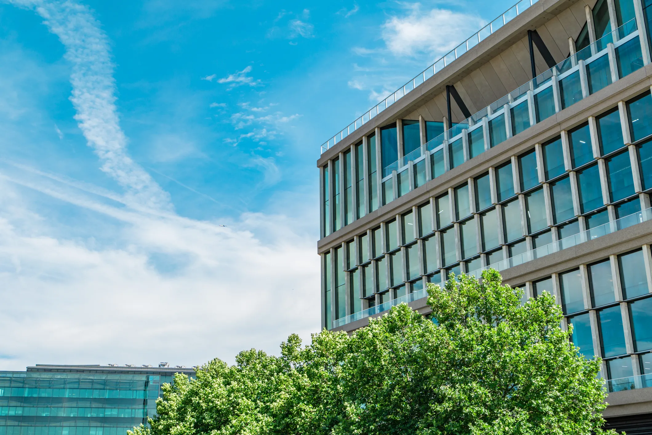 Modern glass office building against a blue sky