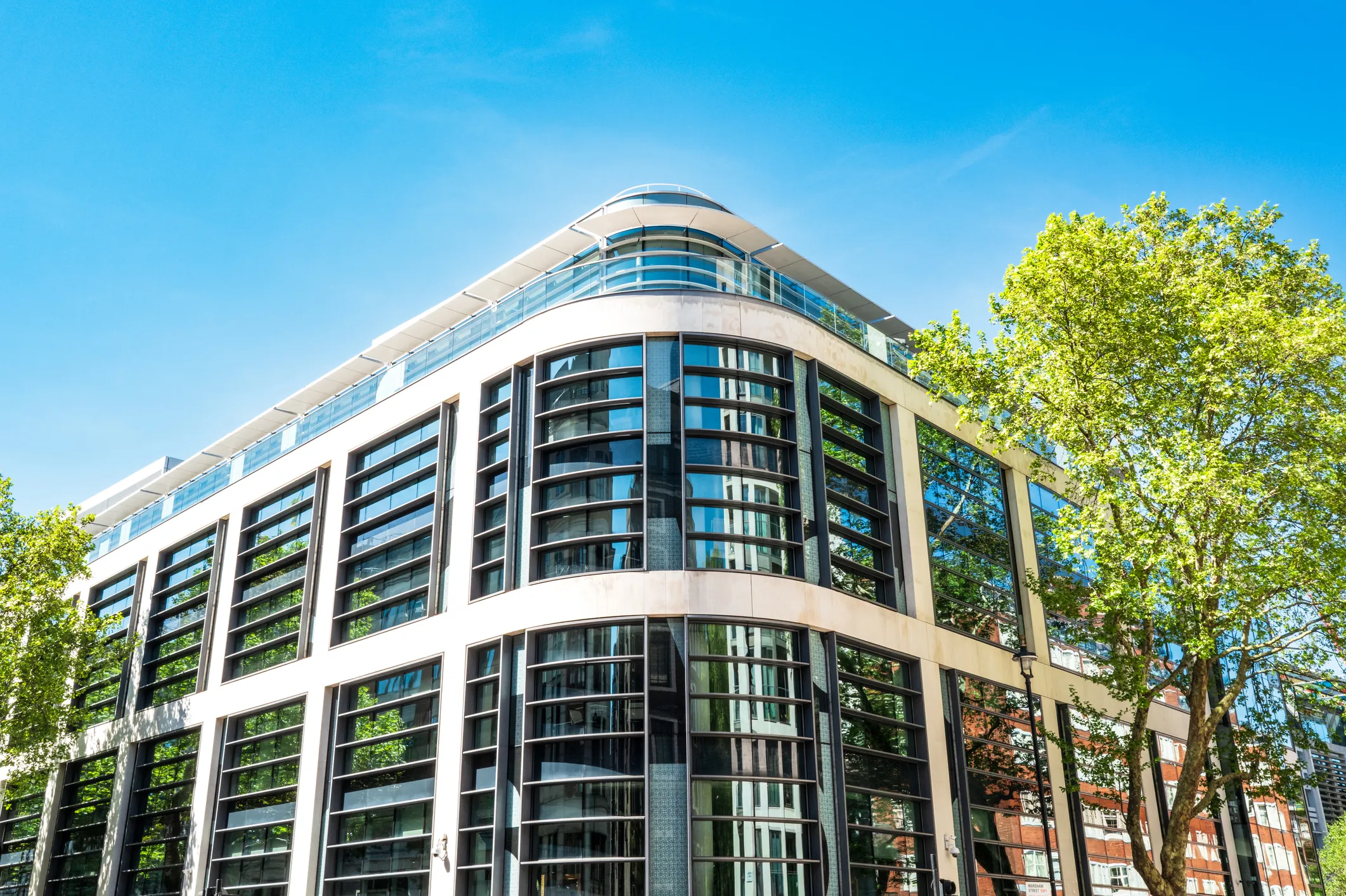 Curved modern office building against a blue sky