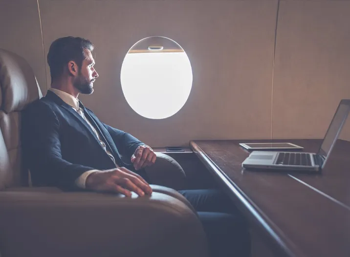 A man sitting in an airplane looking out the window.