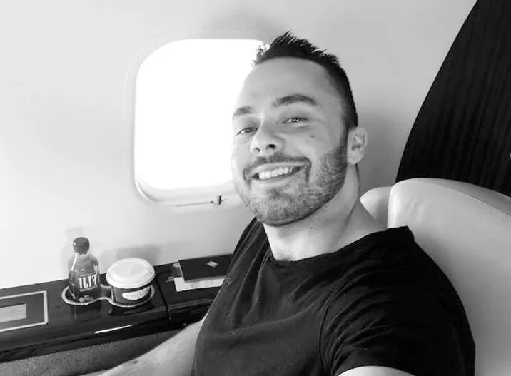 A man sitting in a chair in front of a window.