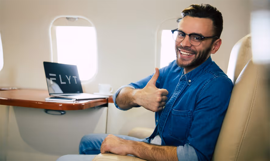 A man giving a thumbs up while sitting in an airplane.