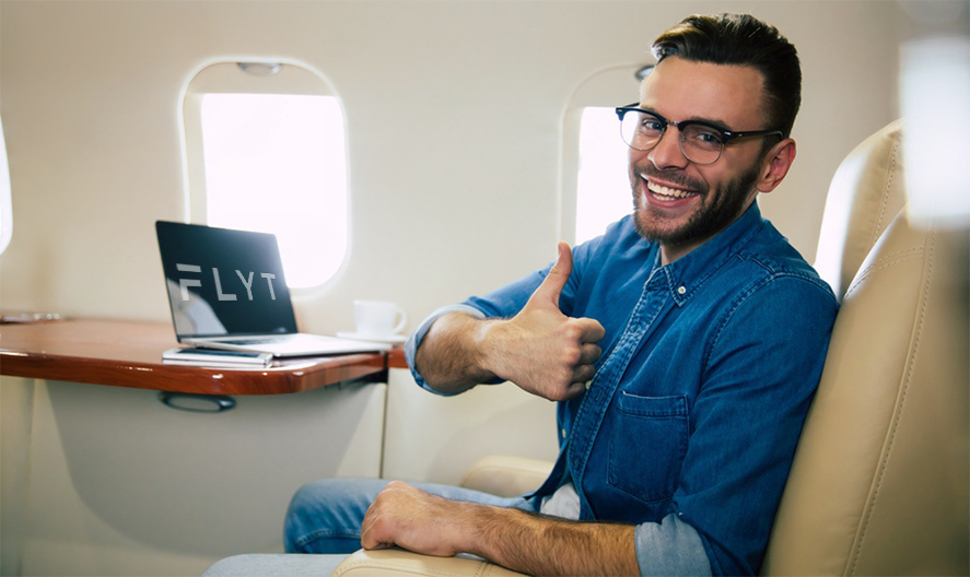A man giving a thumbs up while sitting in an airplane.