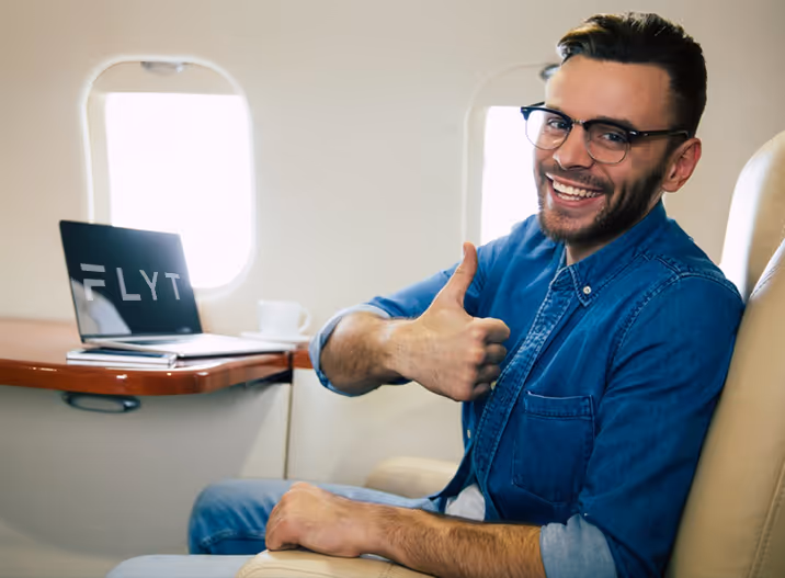 A man giving a thumbs up while sitting in an airplane.