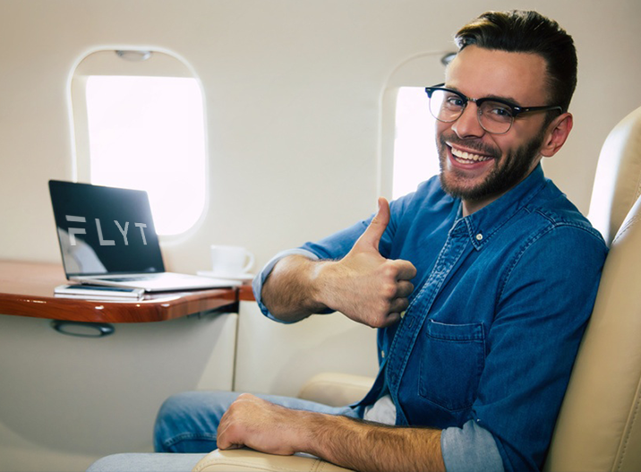 A man giving a thumbs up while sitting in an airplane.