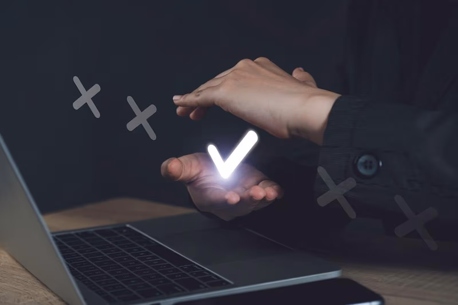 A person using a laptop with a glowing v on the screen.