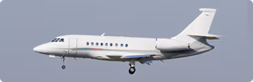 A white airplane flying in the sky with it's landing gear down.