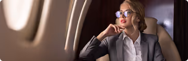 A woman wearing glasses sitting in a chair.