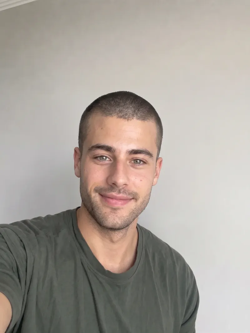 Same person with an AI-generated buzz cut