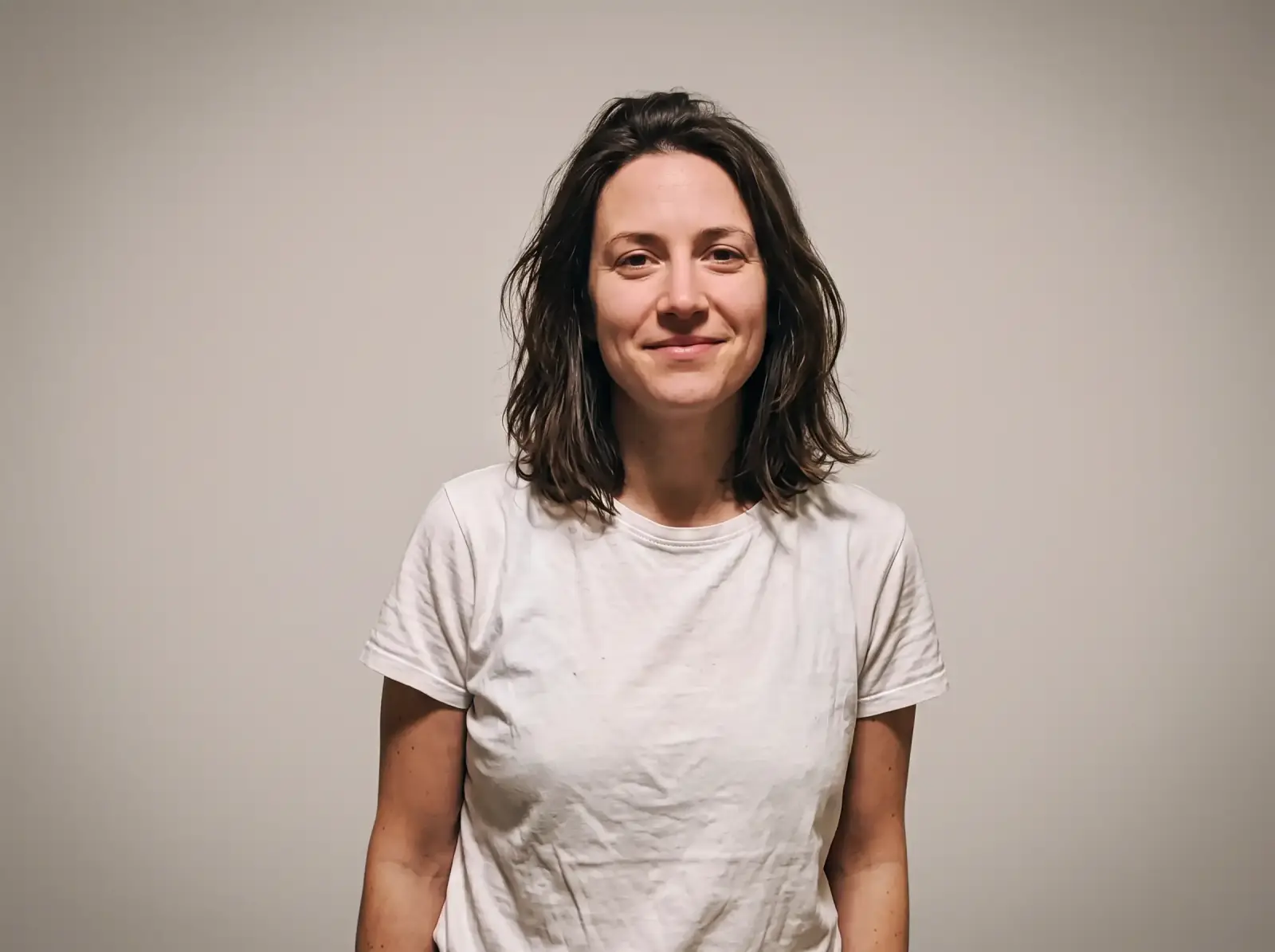 The same woman on a clean grey studio backdrop after the AI background change