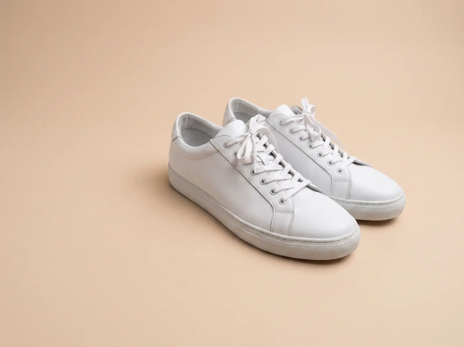 The same sneakers on a seamless beige studio backdrop