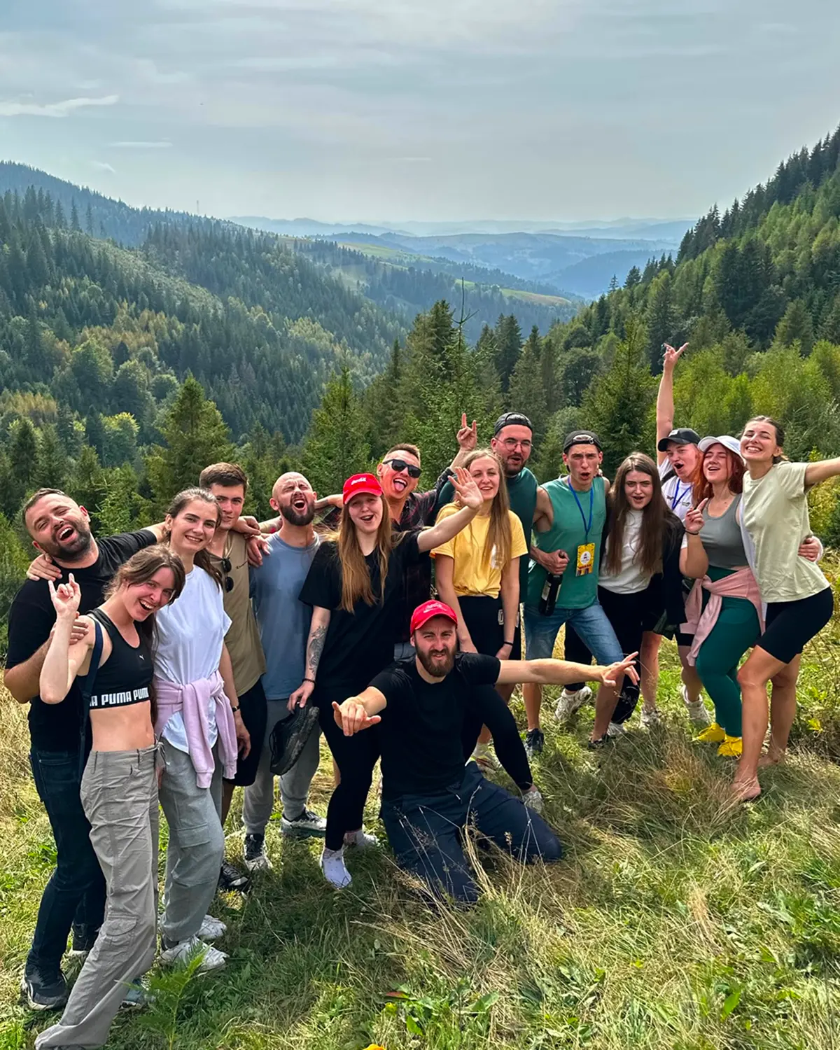 Щасливі люди у горах позують із прпором табору Vatra camp