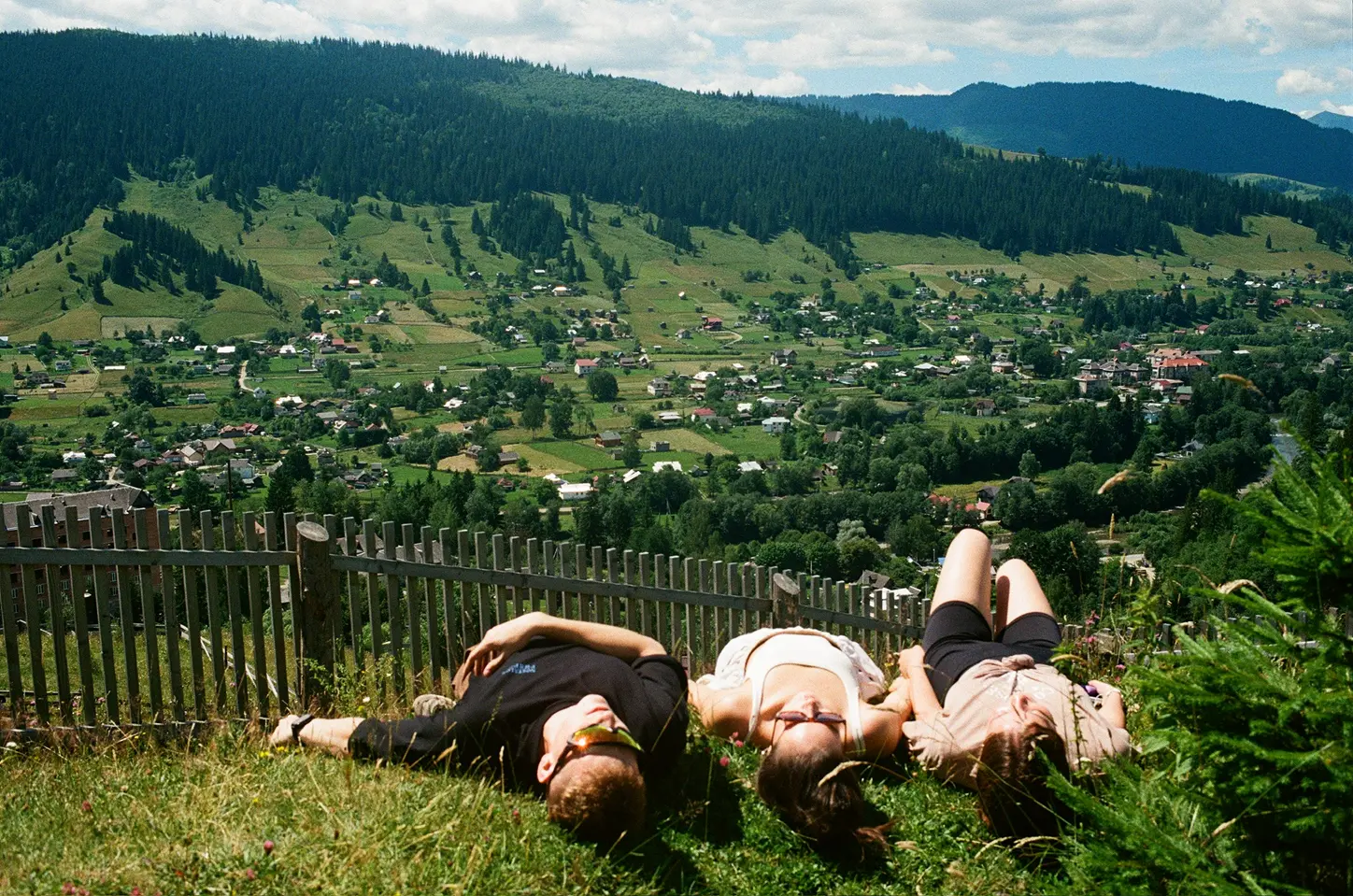 Дівчата лежать на траві у горах відпочиваючи у таборі Vatra camp, ватра кемп