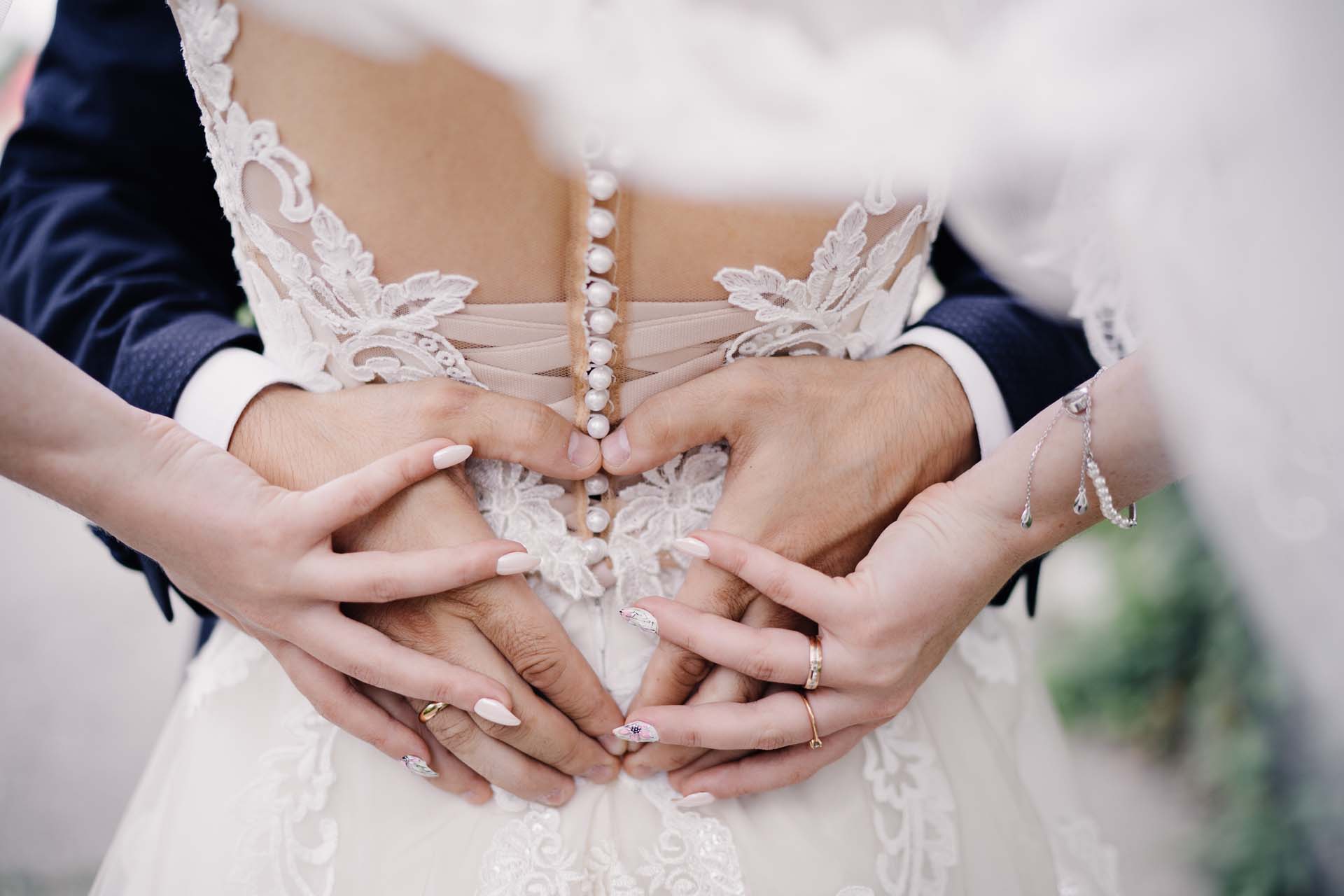 Wedding couple, making a heart shape together using their hands.