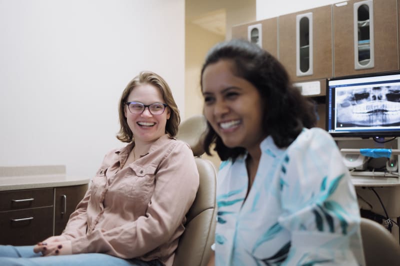 Team member and patient smiling together in dental office setting