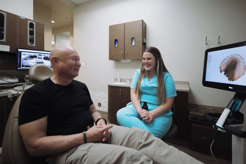 Dentist examining patient in clinical setting with overhead dental light and treatment chair