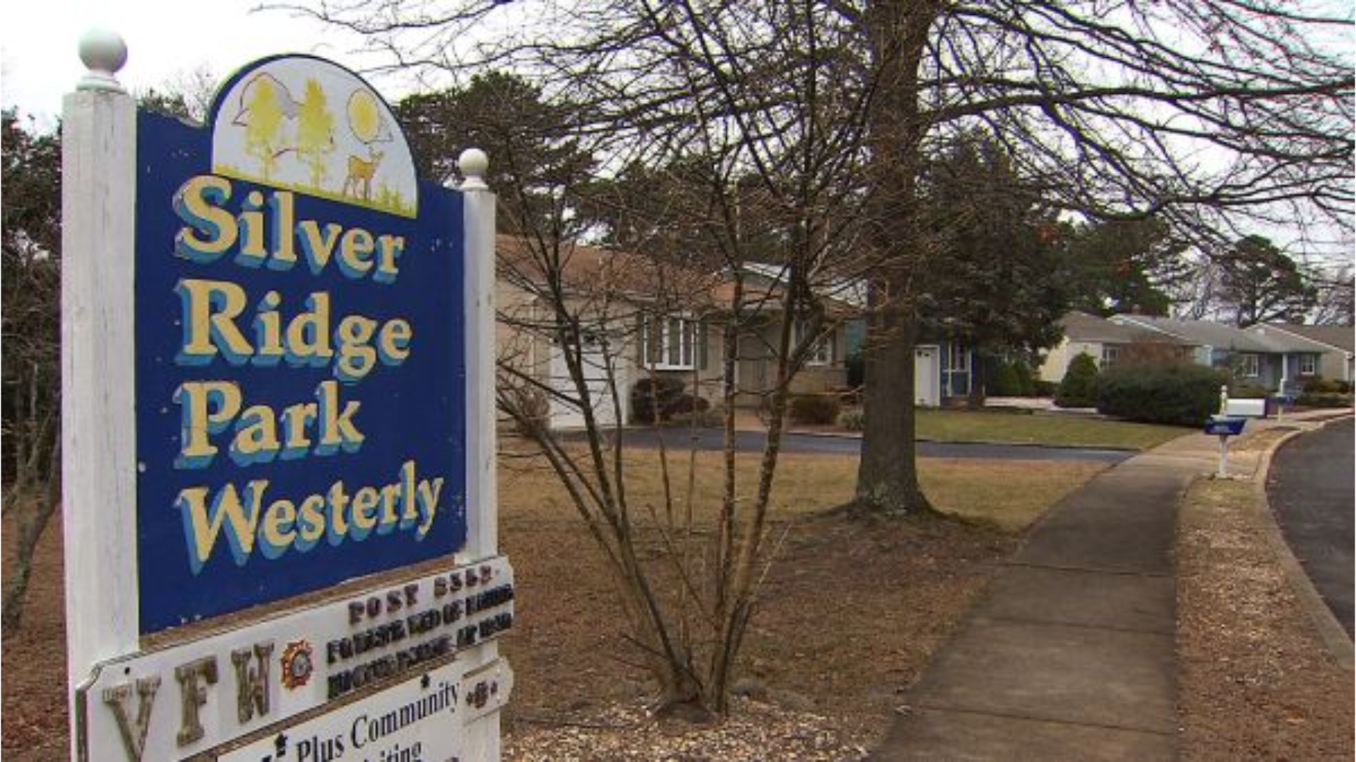 Entrance sign for Silver Ridge Park Westerly, a 55+ adult community in Toms River, NJ, with tree-lined sidewalks, residential homes in the background, and VFW Post 8352 signage below.