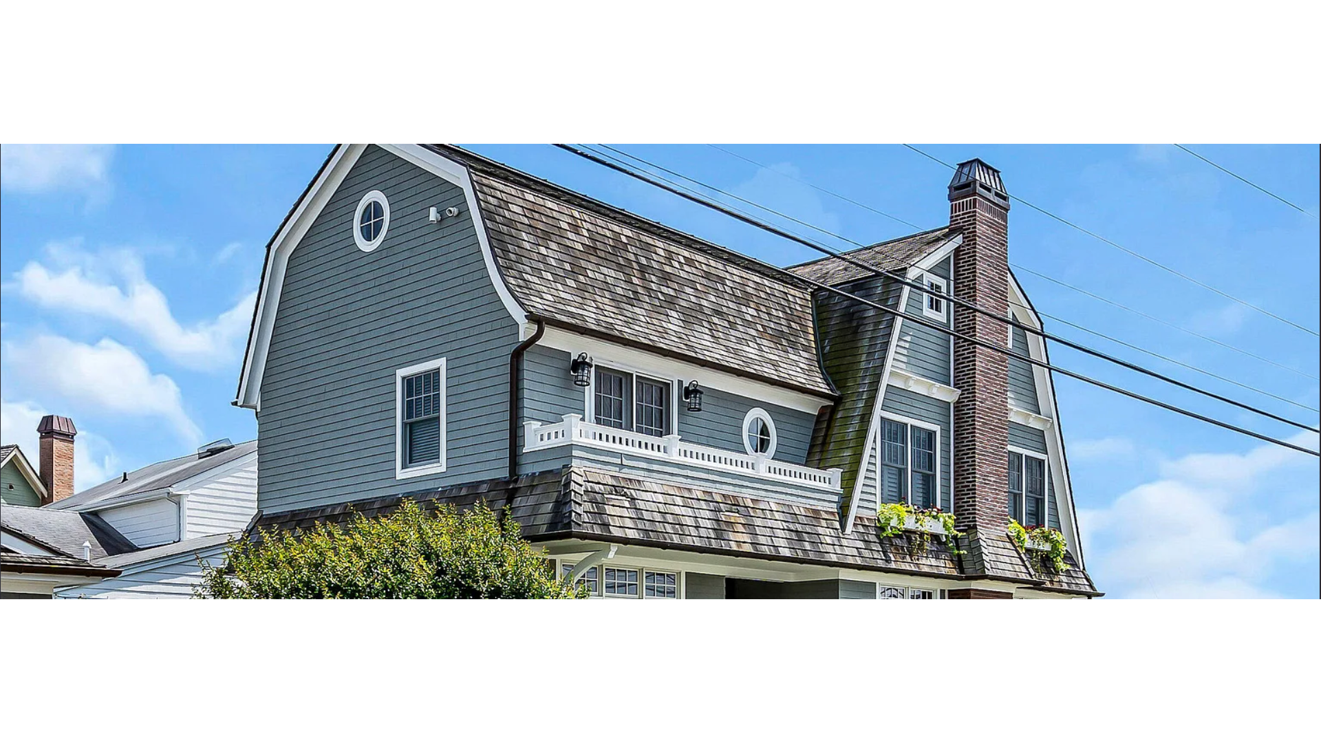 Charming coastal-style home in Manasquan, NJ with wood shake roofing, gray siding, and flower box windows. J.A.Y. Construction is a top choice for roofing and siding at the Jersey Shore.