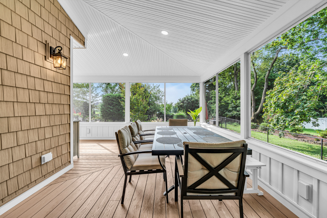 Entryway from exterior deck into screened-in porch addition with white framing and large screened panels