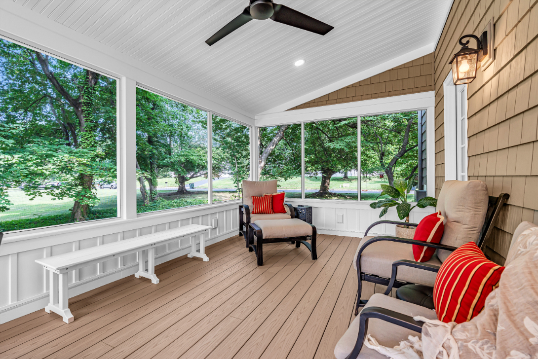 Another interior angle of screened porch addition with comfortable seating and expansive screened windows