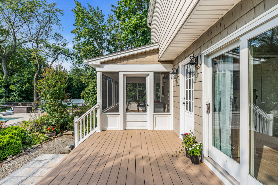Screened-in porch interior highlighting ceiling fan, clean trim work, and garden views in Freehold NJ