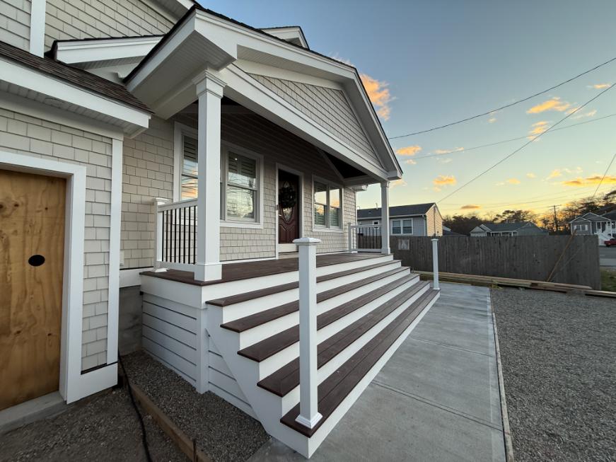 Side perspective of rebuilt front porch in Brick, NJ by J.A.Y. Construction, highlighting precision stair construction with mitered stringers and finished toekicks.
