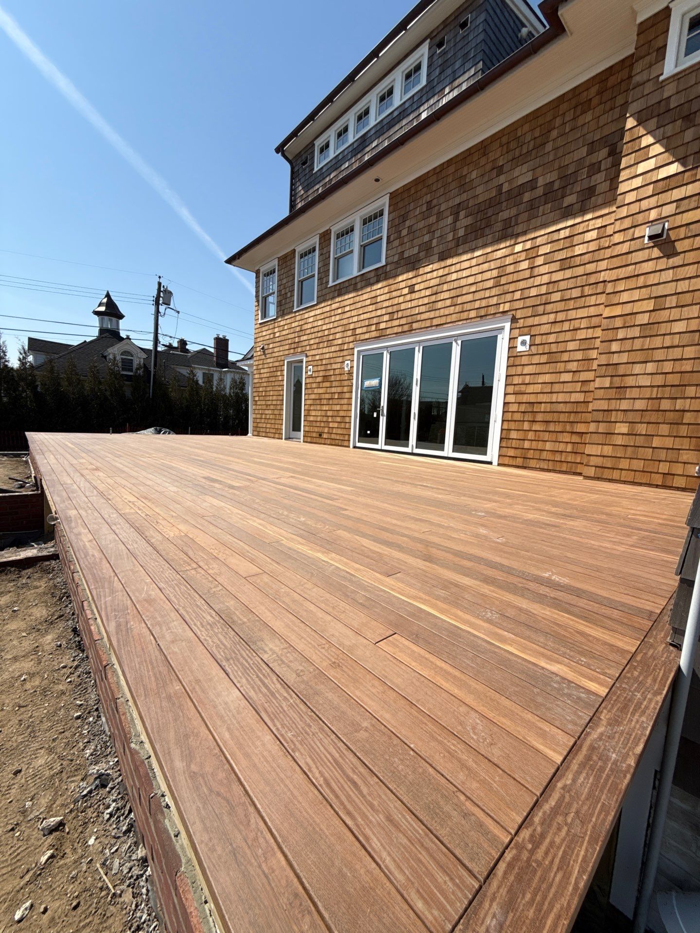 Ipe hardwood deck installation with cedar shake siding and AZEK trim on custom luxury home in Spring Lake NJ by J.A.Y. Construction