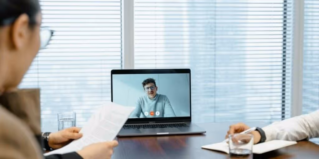 Employees on a video call performing team-building activities. 