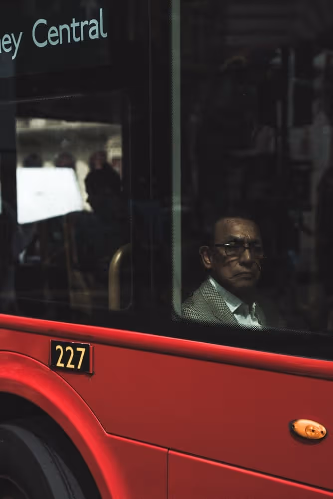 Man sat on public transport looking out window.