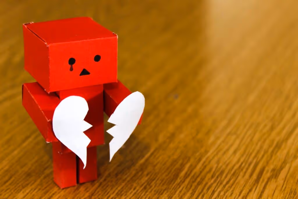 Cardboard robot with broken heart.