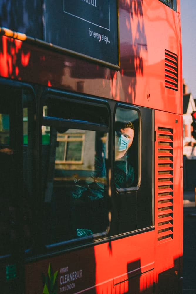 Man sat on bus wearing mask.