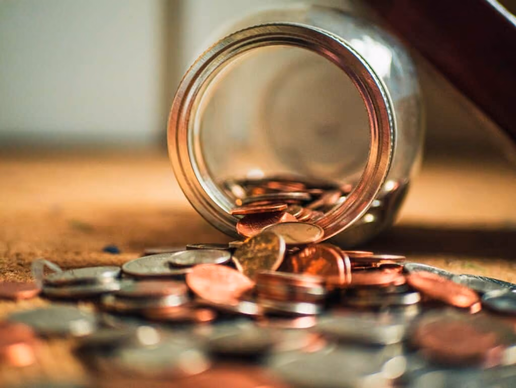 Jar with coins pouring out.