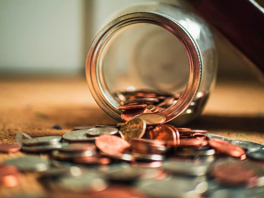 Jar with coins pouring out.