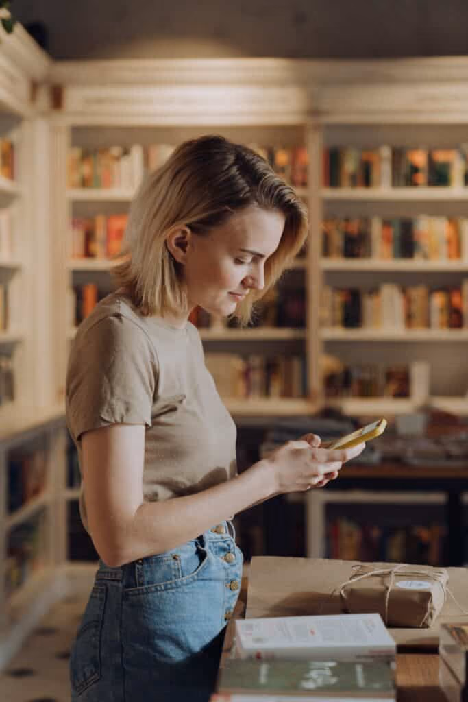Shop assistant smiling at phone.