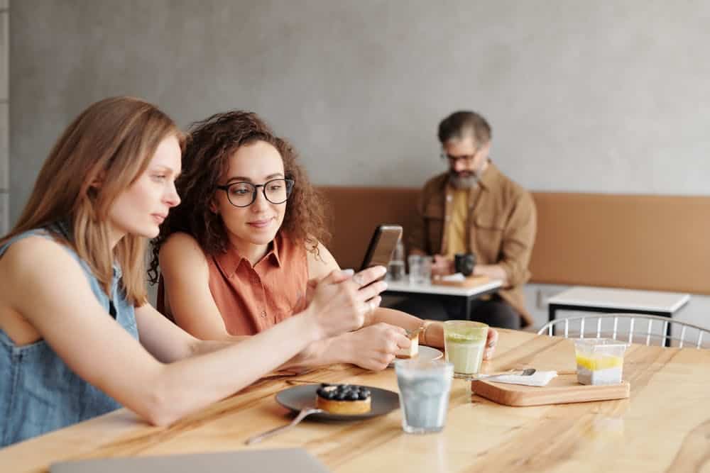 Two women using phone.