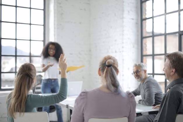 employee town hall meeting with woman raising hand to ask a question