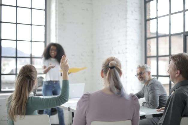 employee town hall meeting with woman raising hand to ask a question